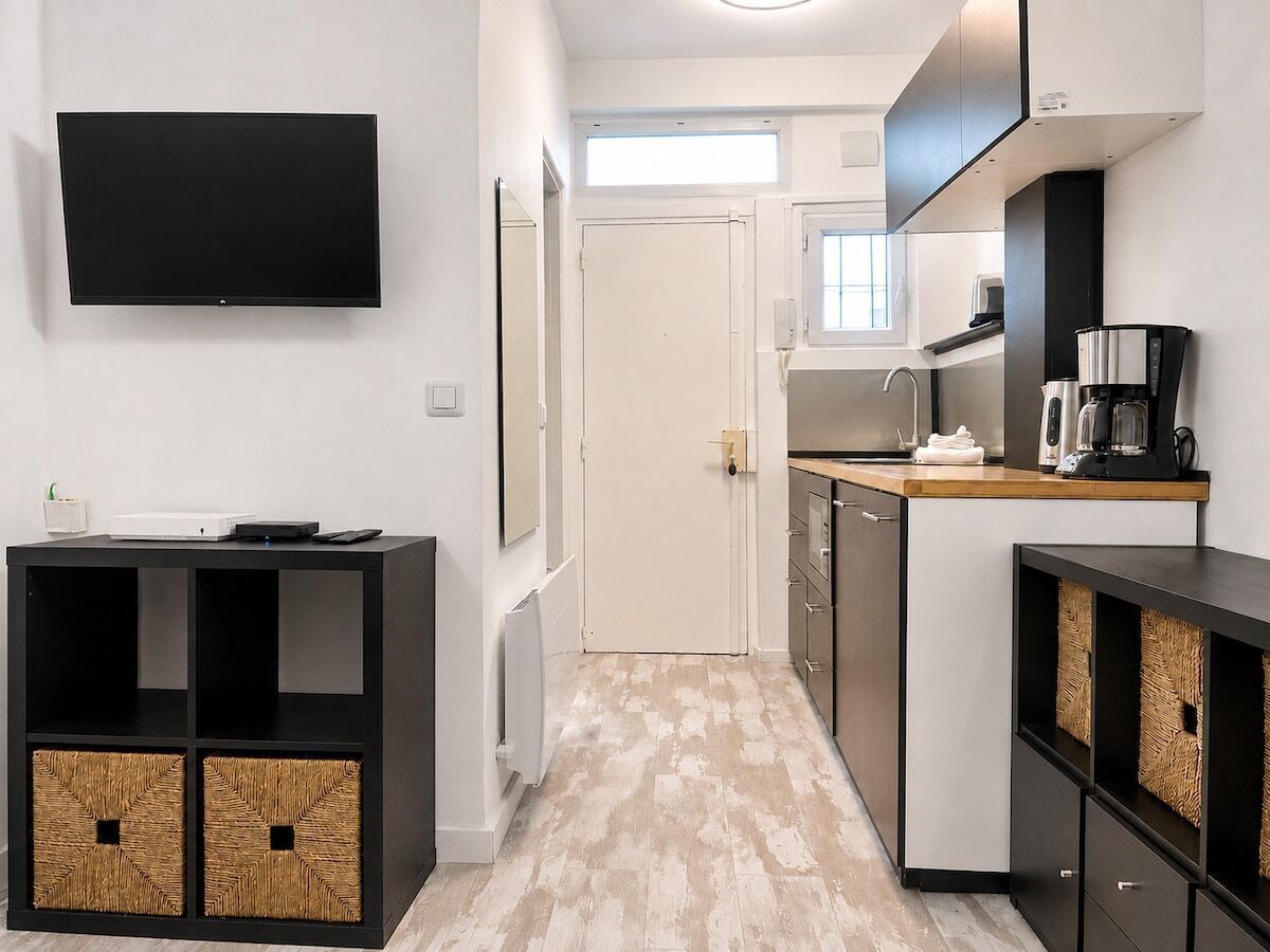 A compact kitchen with a built-in oven, a coffee machine, and a microwave.