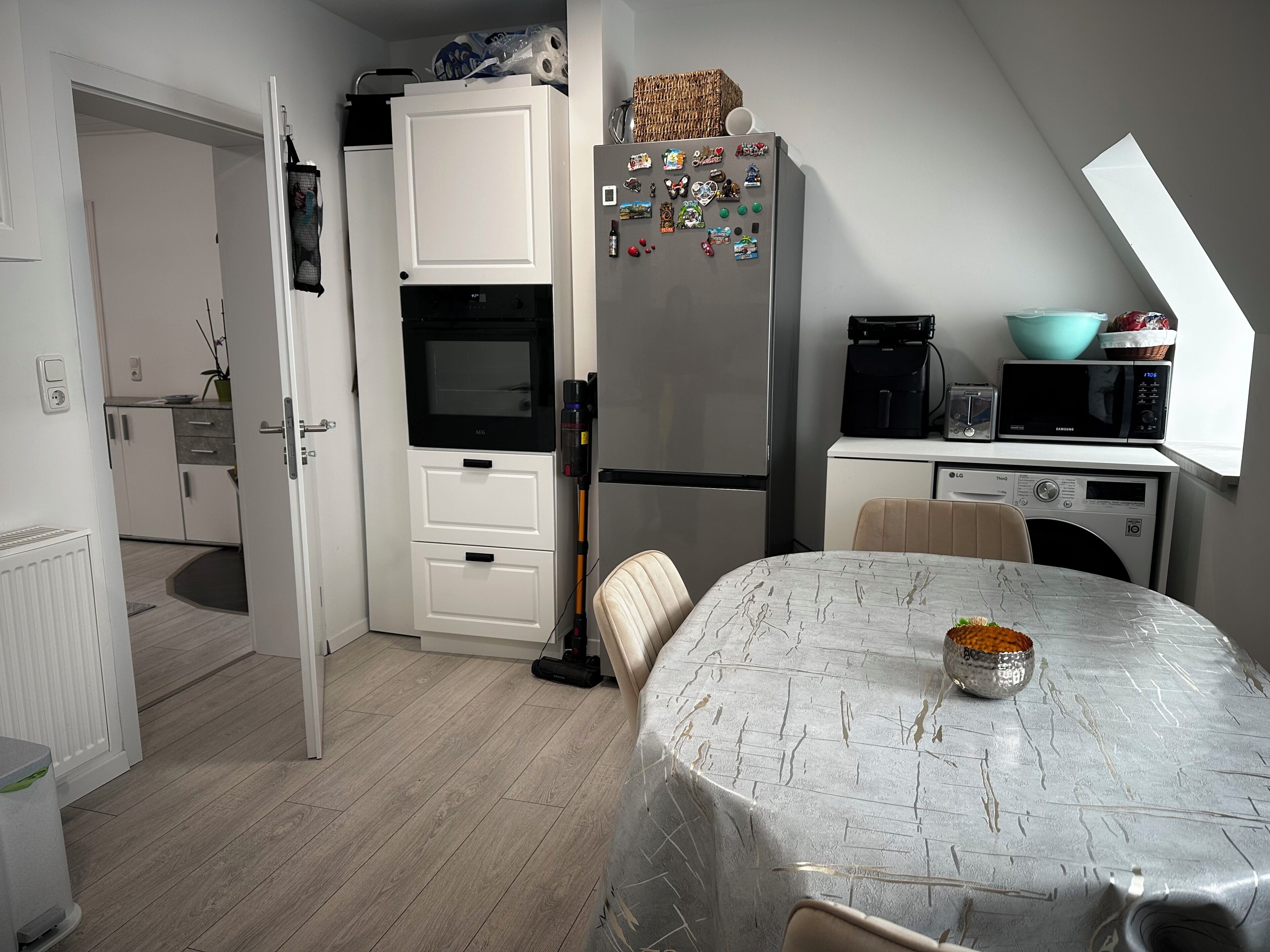 A compact kitchen with a microwave, refrigerator, and a small dining area with a table.