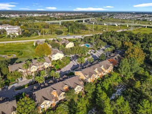A residential area with houses, a swimming pool, and a bridge in the background. - Reunion Resort Getaway Close to Disney World. (Kissimmee)