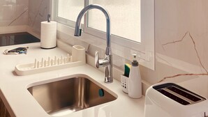 Eine moderne Küche mit einer Edelstahlspüle, einem eingebauten Toaster und einem Fenster über der Spüle.