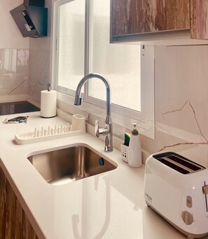 Eine moderne Küche mit einer Edelstahlspüle, einem eingebauten Toaster und einem Fenster über der Spüle.