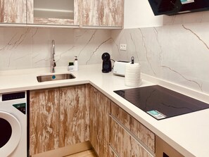 Eine moderne Küche mit eingebautem Geschirrspüler, einer Kaffeemaschine und einem Toaster.