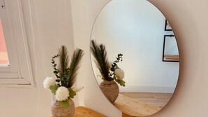A wooden desk with a round mirror and a vase with flowers. - Click&Guest - Doctoral Urbana 2 (Santa Lucía de Tirajana)