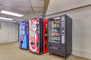 A row of vending machines in a hallway with a plain wall and a door in the background. - Ski, Soak & Relax | Cozy Beech Mountain Condo (Beech Mountain)