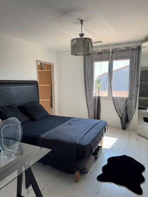 A bedroom with a bed, a desk, a mirror, a wardrobe, and a window with curtains. - A house in the heart of the Camargue. Perfect for a vacation with family or friends (Aimargues)