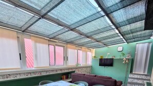 Un área de comedor cubierta con una mesa para dos, sillas y un banco.