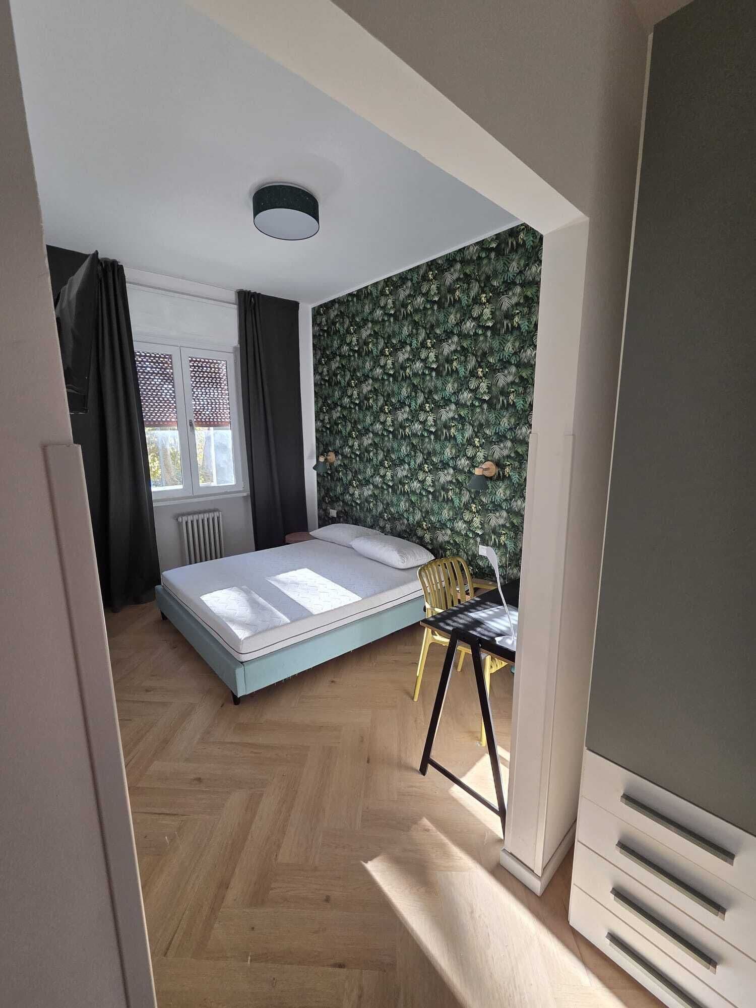 Ein Schlafzimmer mit einem Bett, einem Schreibtisch und einer Heizung.