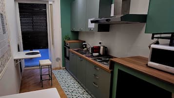 Una cucina compatta con zona pranzo, piano cottura integrato e forno a microonde.