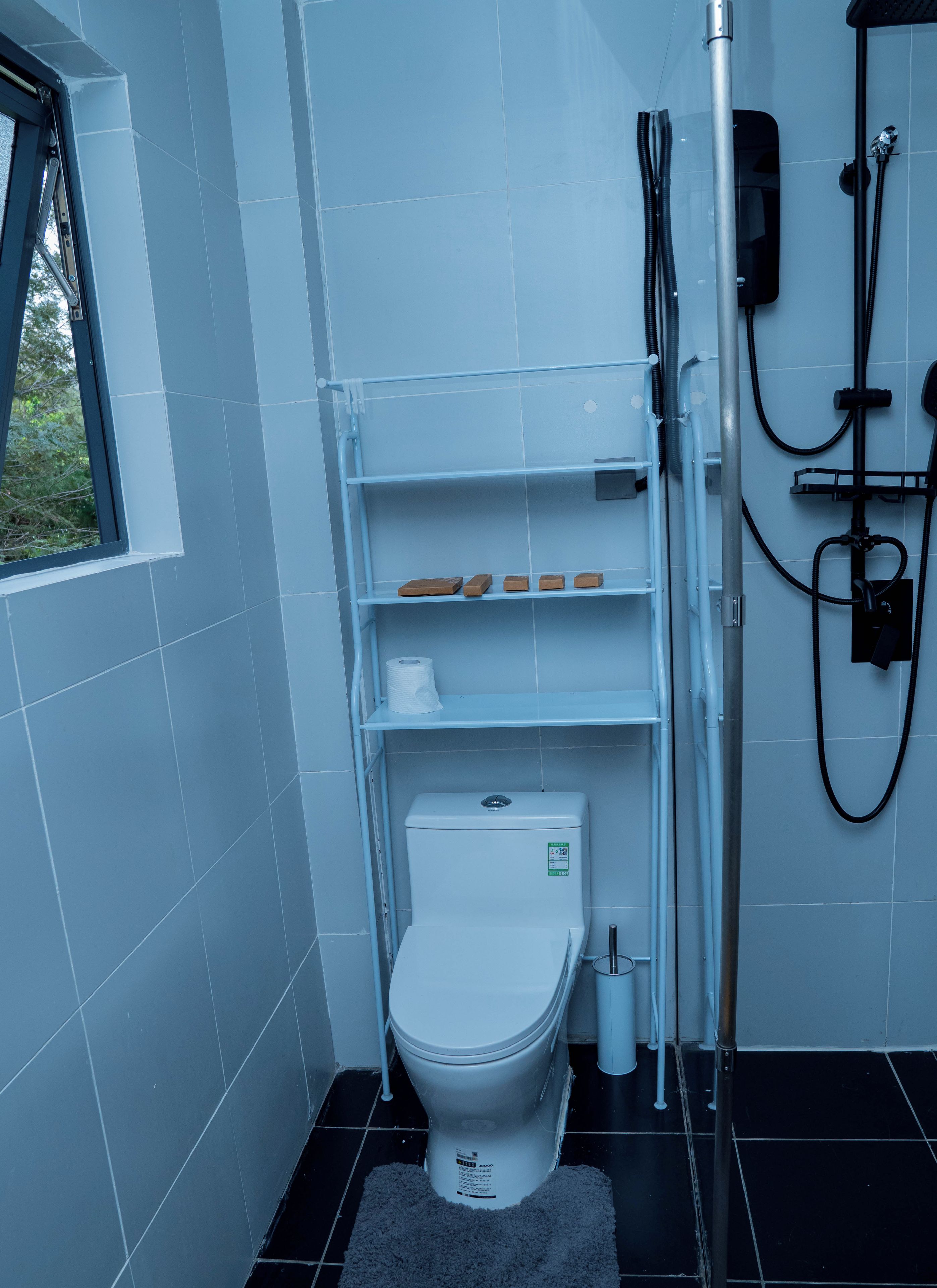 Une salle de bain moderne avec des toilettes, des étagères et une douche.