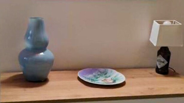 A room with a wooden dresser, a vase, a plate, a lamp, and a mirror. - Gisella's House Vacation Rental (Castellammare del Golfo)