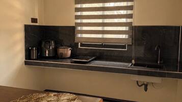 A kitchen with a window, a sink, and a coffee maker.