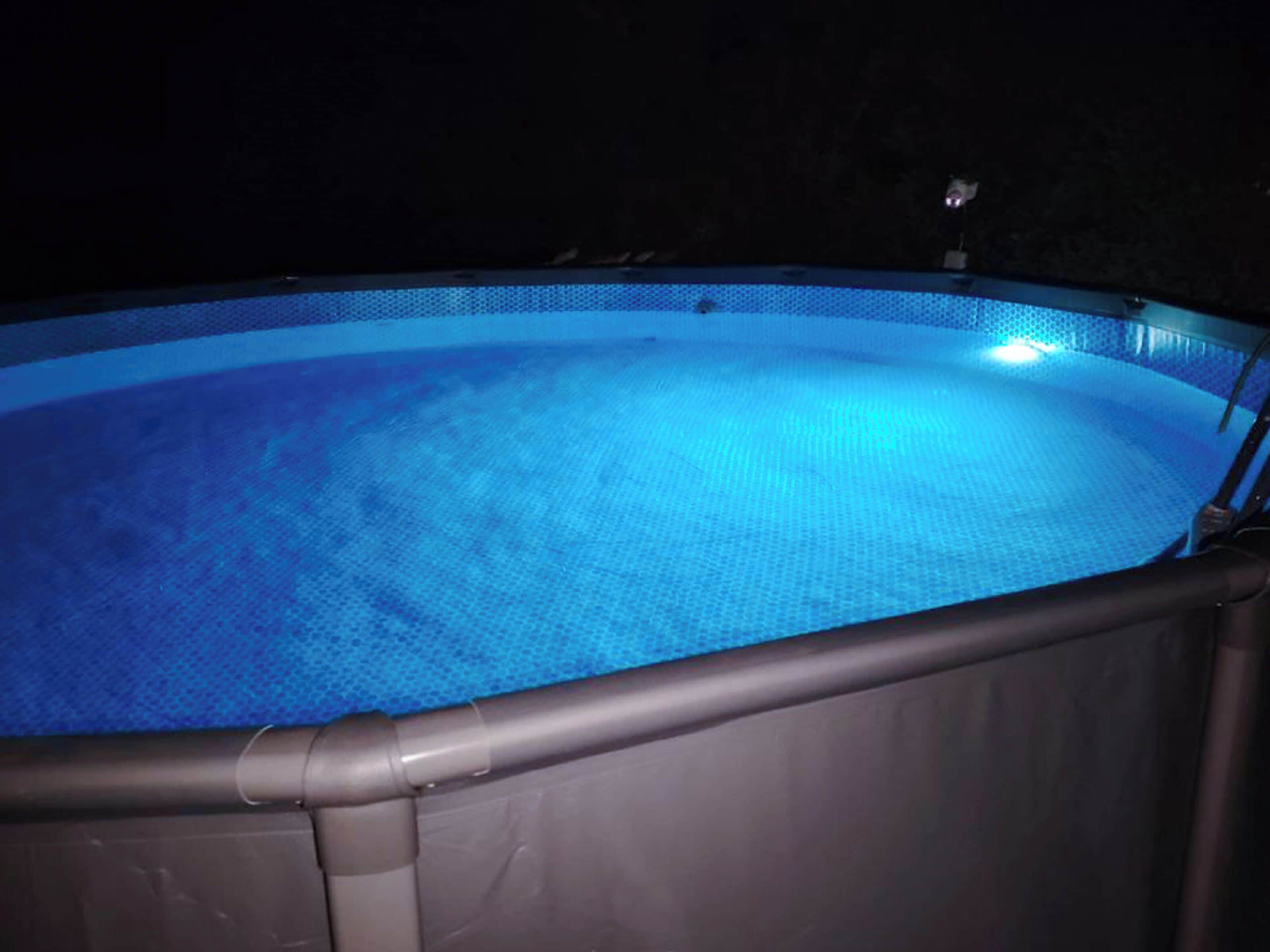 A swimming pool with a dark surrounding area.
