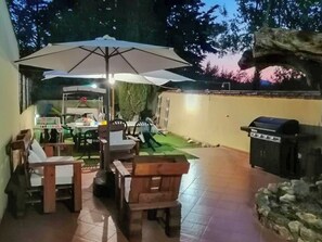 An outdoor patio with a dining table, chairs, and a grill. - Gisella's House (Sicilia)