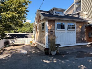 A residential house with a front porch, a garage, and a small attached garage.