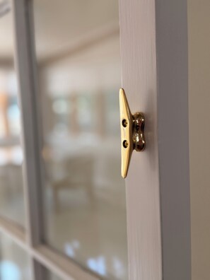 A close-up of a brass door latch on a white door.