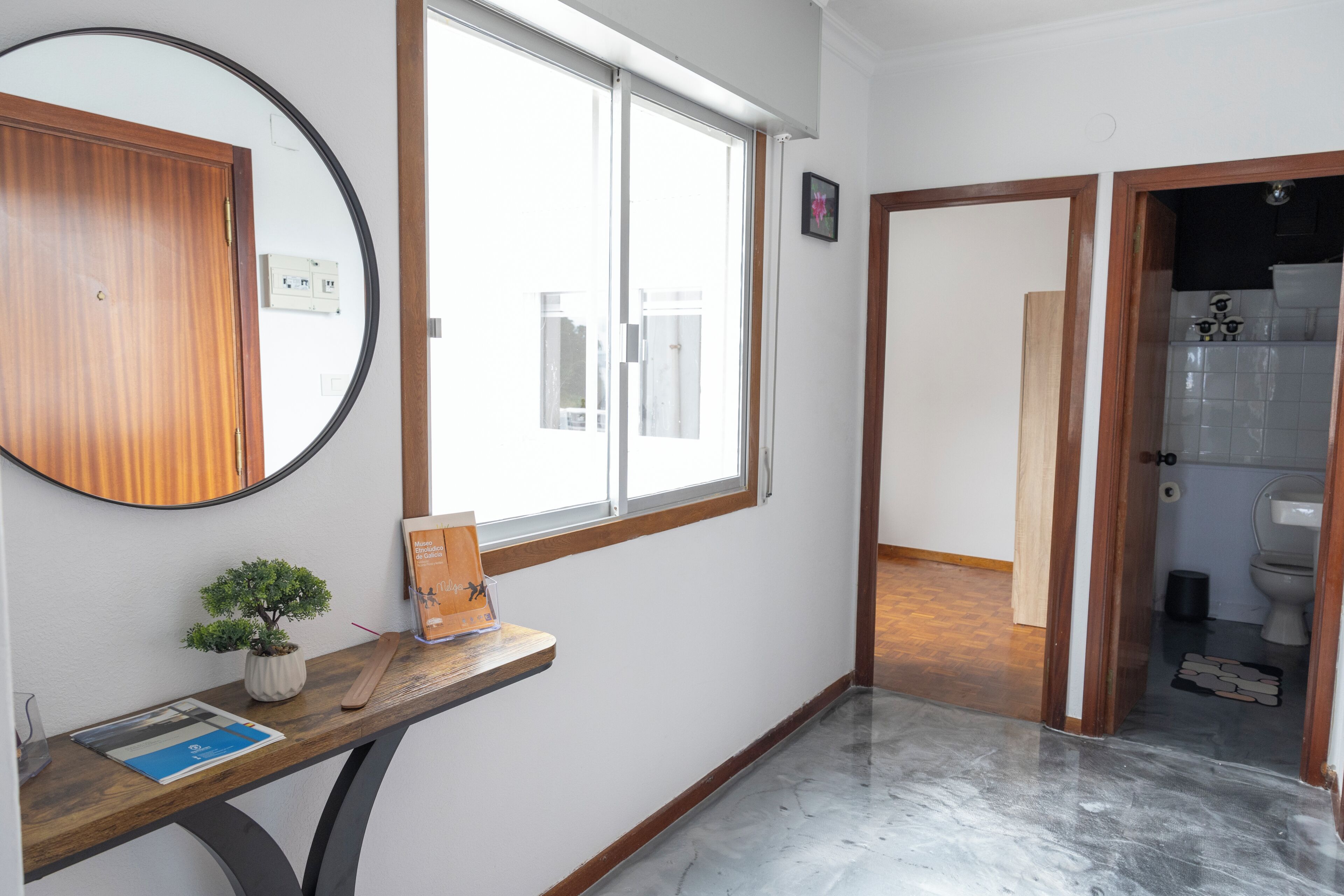 A bathroom with a toilet, a sink, and a mirror.
