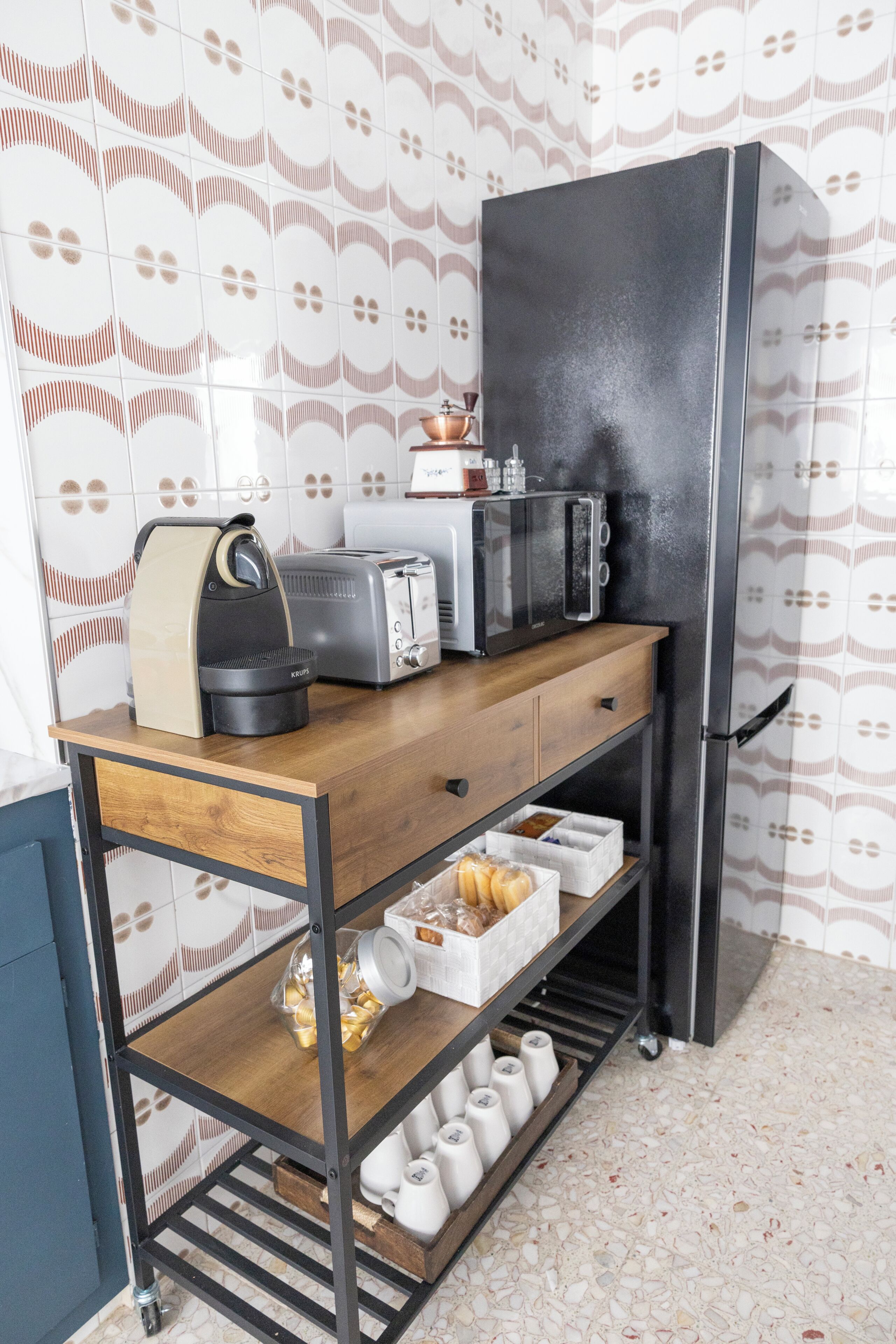 Een kitchenette met een magnetron, broodrooster en koffiezetapparaat op een houten aanrecht.