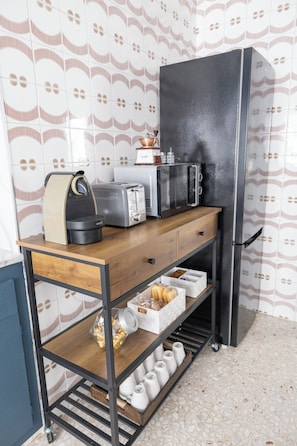 A kitchenette with a microwave, toaster, and coffee maker on a wooden countertop.