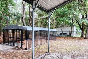 A covered outdoor area with a metal fence and a canopy.
