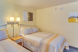 A hotel room with a bed, bedside tables, lamps, and artwork on the walls. - Seas the Day with Ocean Views & a Lazy River (North Myrtle Beach)