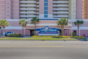 A hotel with a sign reading 'Bay Watch Resort & Conference Center' and a parking lot in front. - Seas the Day with Ocean Views & a Lazy River (North Myrtle Beach)
