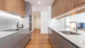 A modern kitchen with stainless steel appliances, wooden cabinets, and a central island. - Polacos Residence | 2BR | Apt J by LovelyStay (Vila Nova de Gaia)