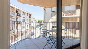 En balkon med gelænder, et klapbord og stole.