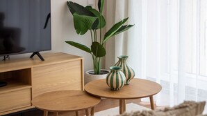 A modern living room with a TV, wooden furniture, and potted plants. - Polacos Residence | 2BR | Apt H by LovelyStay (Vila Nova de Gaia)