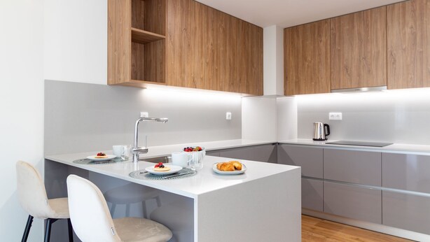 Una cocina moderna con una isla central, horno empotrado y cafetera.
