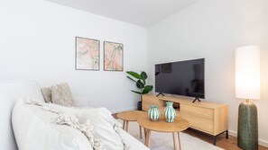 A modern living room with a sofa, a coffee table, a TV, and decorative vases. - Polacos Residence | 2BR | Apt K by LovelyStay (Vila Nova de Gaia)