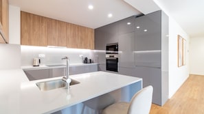 Eine moderne Küche mit integrierter Kochinsel, Edelstahlgeräten und minimalistischem Design.