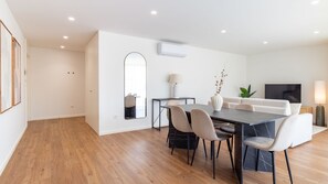 A modern living room with a dining area, white walls, and a wooden floor. - Polacos Residence | 2BR | Apt S by LovelyStay (Vila Nova de Gaia)
