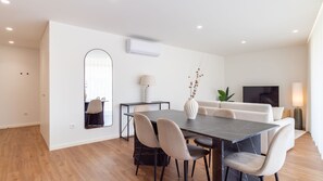 A modern dining area with a marble table, chairs, a mirror, and a vase with dried flowers. - Polacos Residence | 2BR | Apt S by LovelyStay (Vila Nova de Gaia)