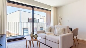 Ein modernes Wohnzimmer mit einer Couch, einem kleinen runden Tisch und einer Vase.