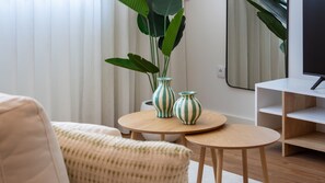 A modern living room with a sofa, two round wooden tables, and two striped vases. - Polacos Residence | 1BR | Apt D by LovelyStay (Vila Nova de Gaia)