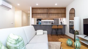 Ein modernes Wohnzimmer mit einem weißen Sofa, einem kleinen Couchtisch und zwei gestreiften Vasen.