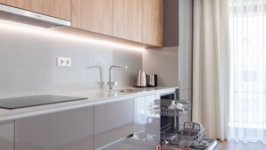 Una cocina moderna con extractor Bosch, electrodomésticos de acero inoxidable y lavavajillas.