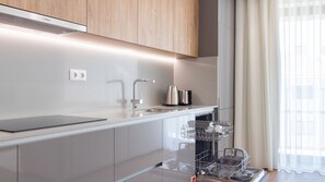 Eine moderne Küche mit Bosch-Dunstabzugshaube, Edelstahlgeräten und einem Geschirrspüler.