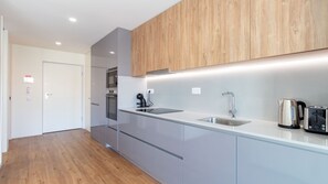 A modern kitchen with a stainless steel sink, a kettle, and a toaster. - Polacos Residence | 1BR | Apt Y by LovelyStay (Vila Nova de Gaia)