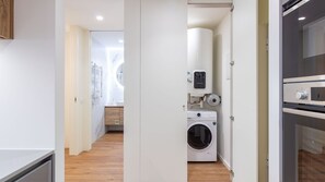 Een wasserette met een wasmachine, een droger en een boiler.