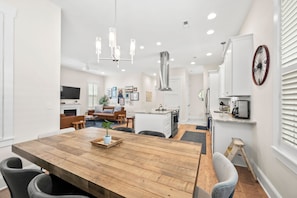 A modern kitchen with white cabinets, a wooden dining table, and a central island. - Downtown Delight on Main Street - Brevard, NC (Brevard)