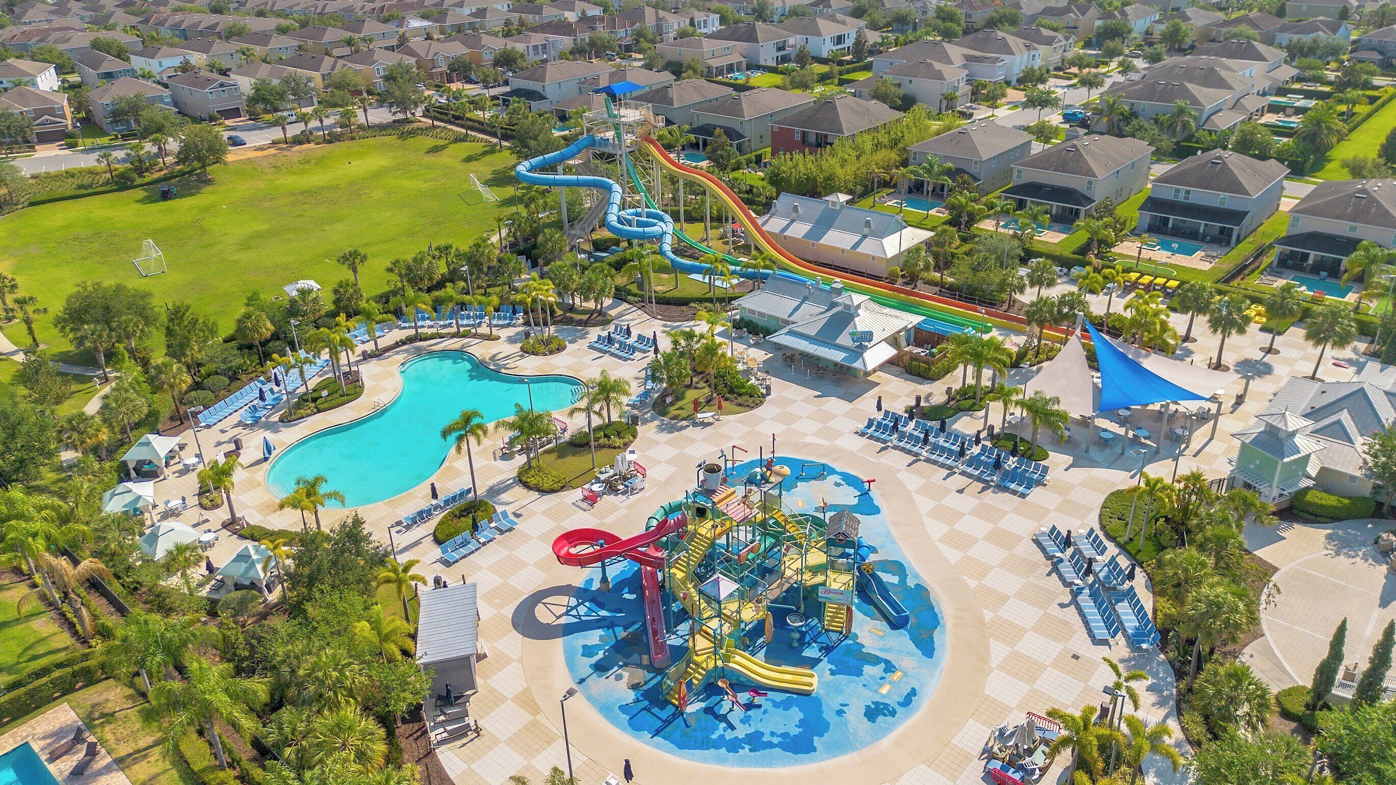 An aerial view of a resort with multiple swimming pools, a water park, and a golf course.