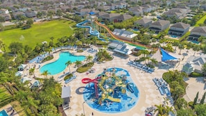 Een luchtendicht uitzicht op een resort met meerdere zwembaden, een waterpark en een golfbaan.