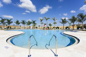 A swimming pool with palm trees, lounge chairs, and a clear blue sky. - The Encore Bliss - Nine Bedroom Apartment, Sleeps 18 (Kissimmee)