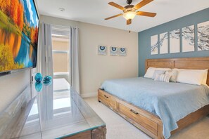A bedroom with a bed, a ceiling fan, a TV, and artwork on the wall. - The Encore Bliss - Nine Bedroom Apartment, Sleeps 18 (Kissimmee)