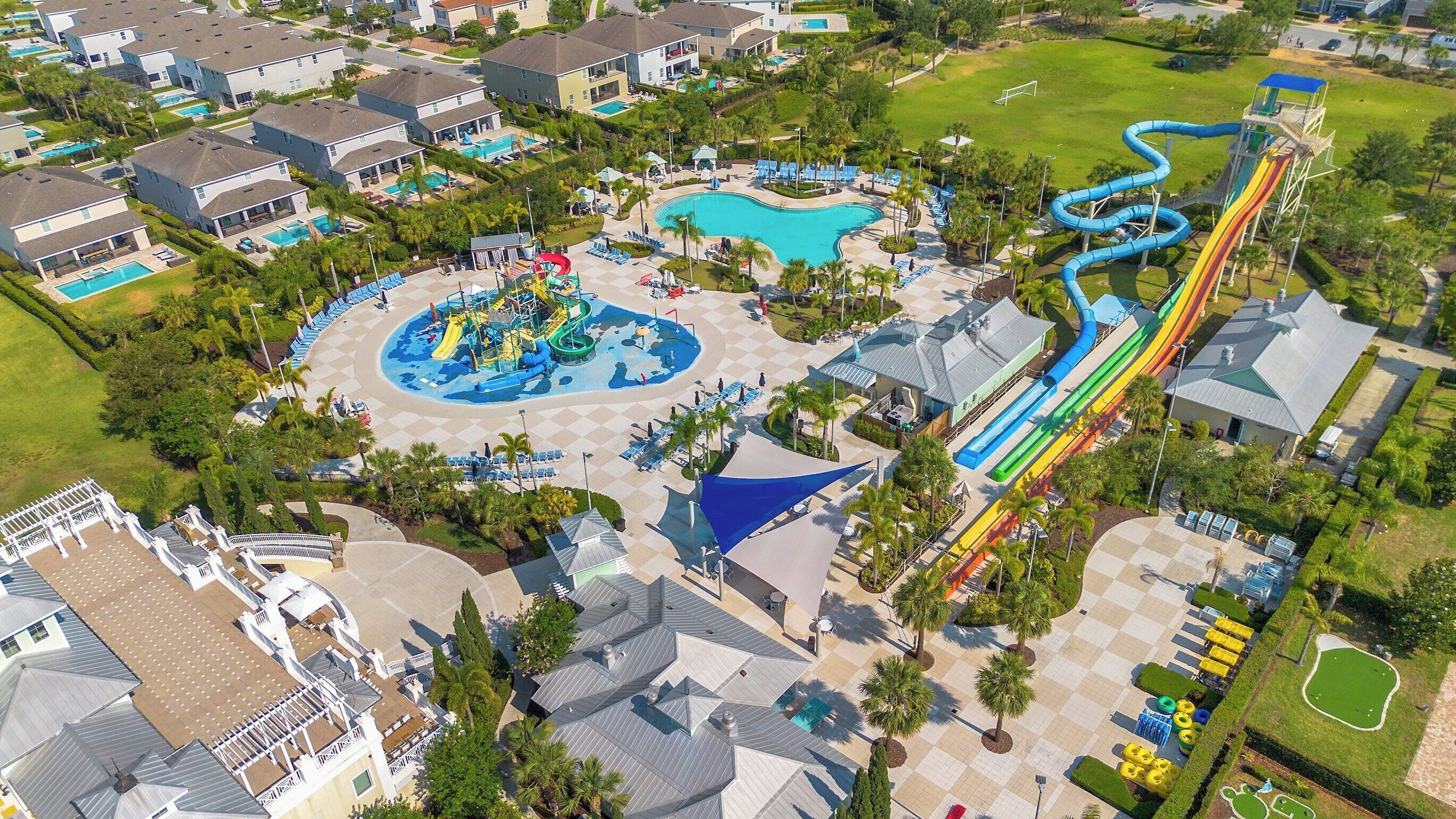 An aerial view of a resort with multiple swimming pools, a water park, and a large slide.