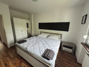 Une chambre à coucher comprenant un lit, une armoire, une table de chevet et une commode.