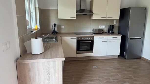 Eine moderne Küche mit Backofen, Edelstahl-Kühlschrank und Toaster.