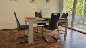 Ein Essbereich mit Tisch, Stühlen und Kunstwerken an den Wänden.