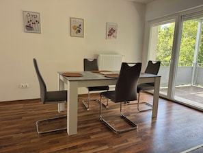 Un espace repas comprenant une table, des chaises et des œuvres d’art accrochées aux murs.